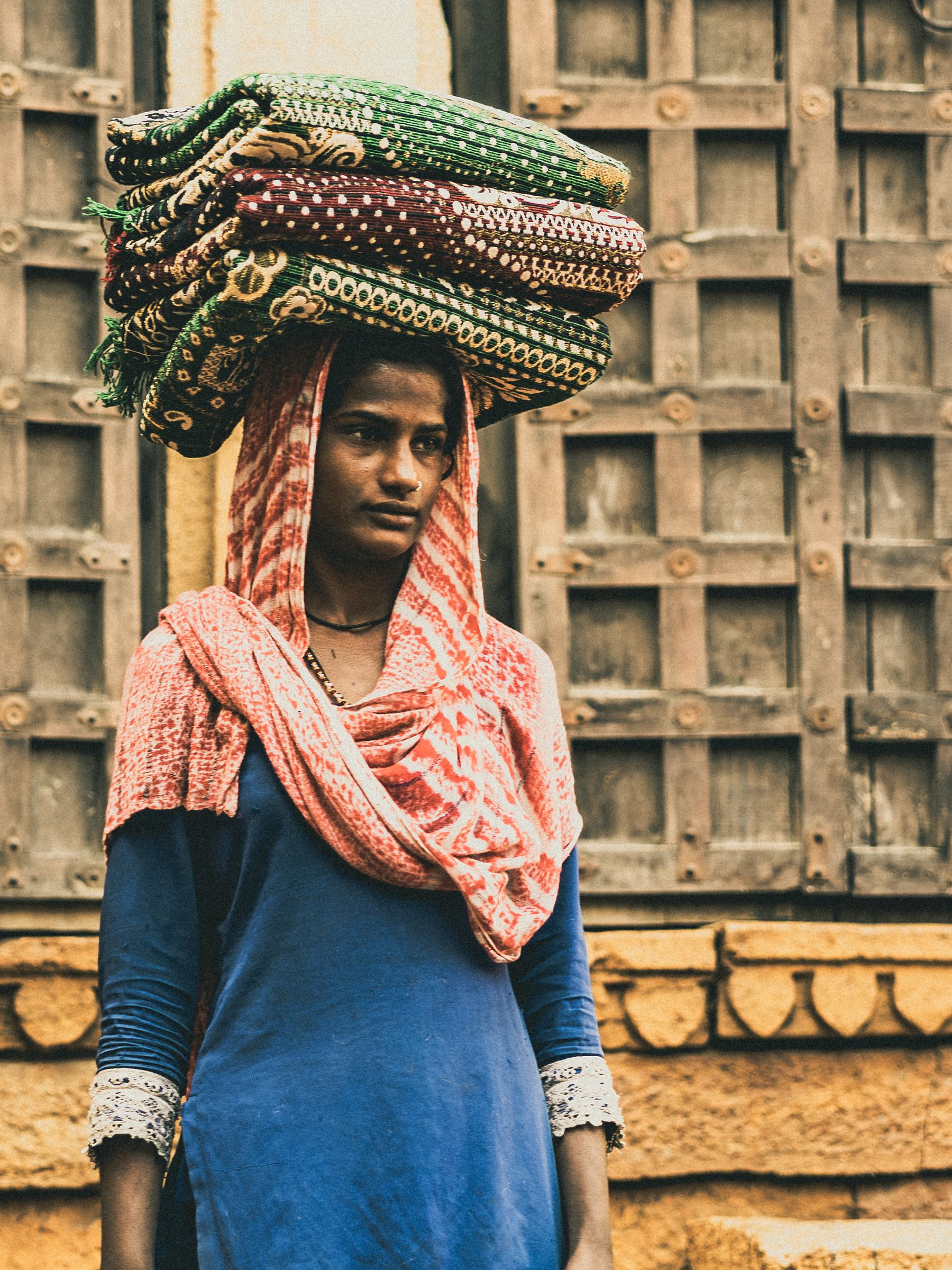 Young Vendor Carrying Folded Textiles On Head